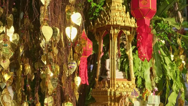 Thai Buddha altar, offerings, lanterns, golden leaves of Bodhi tree