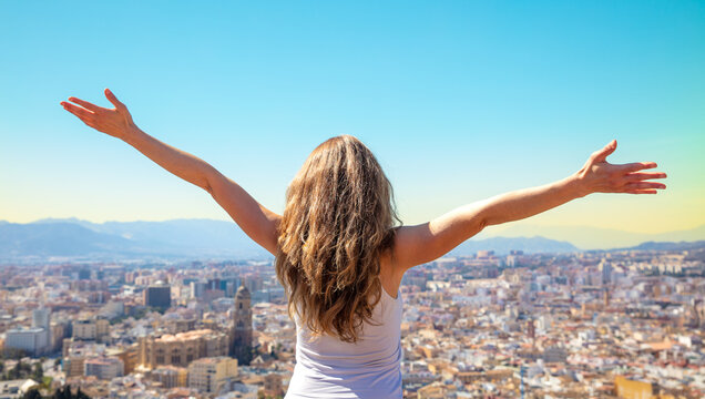 Happy Free Woman With Arms Up Admiring Skyling Of Malaga City- City Skyline With Arms Outstretched Raised In The Sky- Success,  Travel,  Active Life Concept