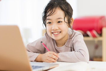 Naklejka premium パソコンを見ながら勉強する女の子