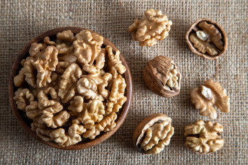Peeled walnuts and whole walnuts on burlap sack
