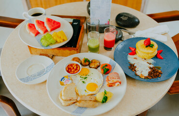 Breakfast food table. Festive brunch set, meal variety with fried egg, croissant sandwich, beef and smoothie.