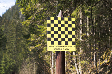 Danger - Avalanche area warning sign in Tatra mountains. Avalanche area warning sign in english and polish language, valley in Tatra mountains, Spring time