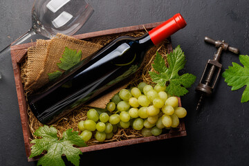 Obraz premium A red wine bottle and fresh grapes