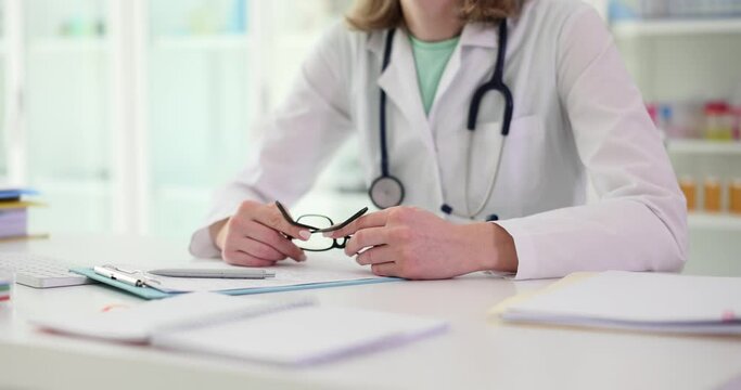 Optometry glasses and optometrist hand holding glasses in workplace. Glasses or specifications for ophthalmology in office