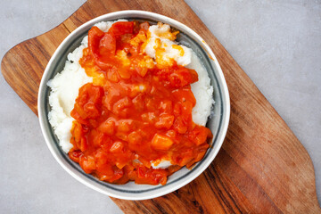 Traditional South African pap or maize meal with traditional sauce of tomato and onion on wood and...