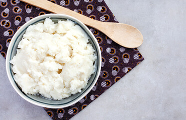 flat lay of Traditional South African pap or maize meal served plain in a bowl with wooden spoon on...