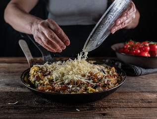 Chef preparing food. Puts grated cheese over a farmers breakfast