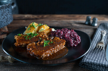 Meatloaf with gravy, red cabbage and boiled potatoes. Traditional german meat dish