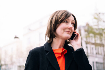 Woman wearing black blazer talking on phone