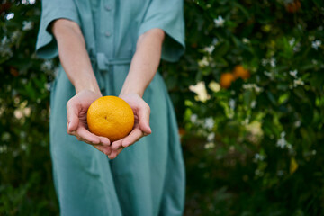 Woman holding fresh orange in cupped hands