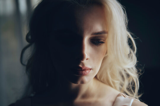 Depressed blond woman in darkroom