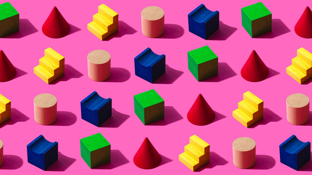 3D pattern of colorful toy blocks flat laid against pink background