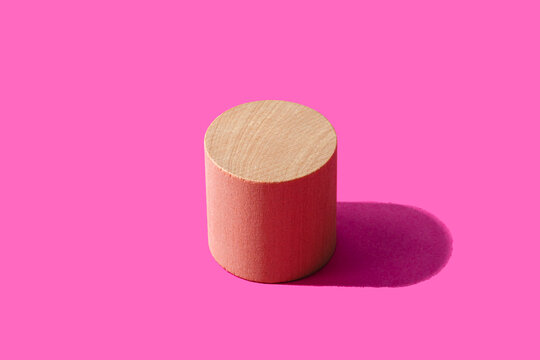 3D render of wooden cylinder against pink background