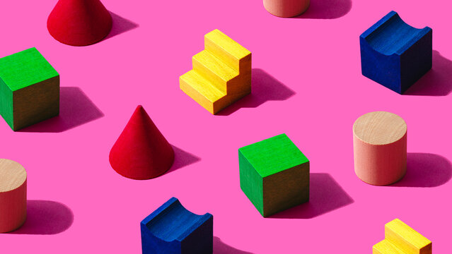 3D pattern of colorful toy blocks flat laid against pink background