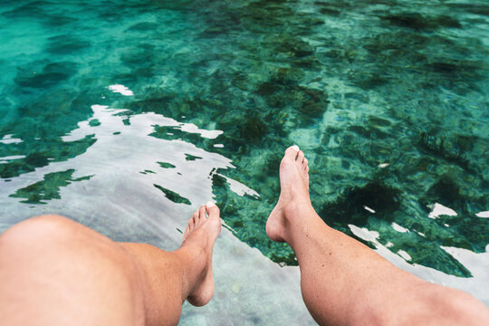 Legs of man above sea at vacation