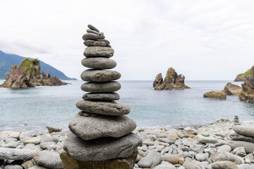 Pebble tower balance harmony stones arrangement on sea beach coastline
