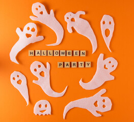 White ghosts craft for Halloween party. Wrapping paper ghost on orange background top view. Cartoon creepy Whisper. DIY hand made. Set boo characters. Word wooden letter phrase.
