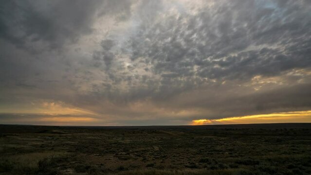 Time lapse sunset light through racing clouds over prairie