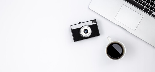 Laptop, coffee cup and retro camera on white background, top view.