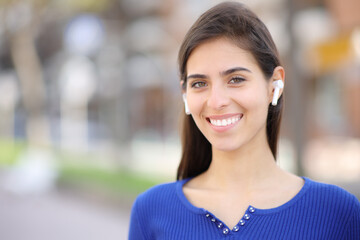Happy woman with earphone in the street