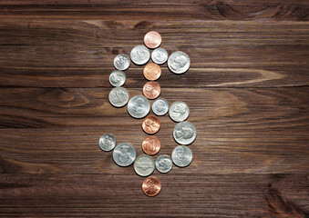 Dollar Sign Made of American Coins on Dark Wooden Table