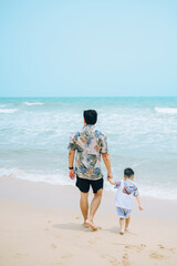 Fototapeta na wymiar Happy fother and son resting at beach in summer,Thailand