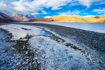 Panorama landscape of Pangong lake with mountain background under winter blue sky.Pangong tso with cloudy sky.Natural beauty of Ladakh,India. Famous tourist place in the world.China and India border.