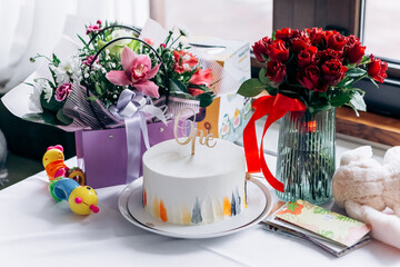 Happy birthday! Close up image first birthday sweet cake surprise number one inscription with burning candle, presents gifts flowers
