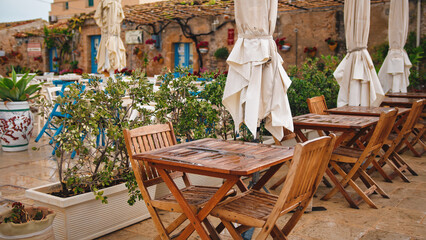 Fototapeta na wymiar Outdoor table of a restaurant in the main square of Marzamemi city in Sicily