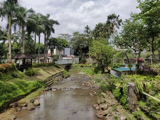 Fototapeta na wymiar View of a small river flowing through a tropical garden in a luxury hotel