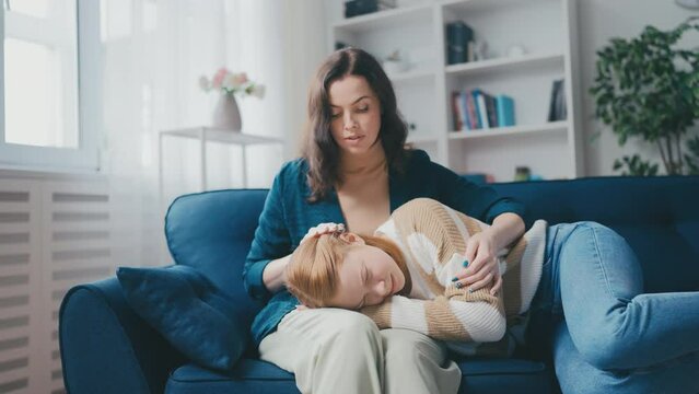Middle-aged mother comforting her crying teen daughter, broken heart, first love
