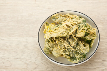 Keripik Bayam (Spinach Crackers) served on white plate. Indonesian traditional snack
