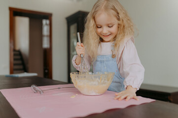 knead the dough. little girl kneads dough for cookies, cake, bread, pancakes.