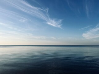 Blue sea horizon with some light clouds, seascape background