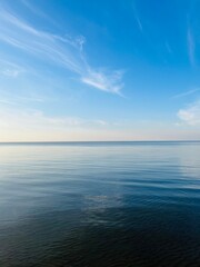 Obraz premium Blue sea horizon with some light clouds, seascape background