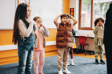 Kids sing and move along to an educational rhyme in a classroom