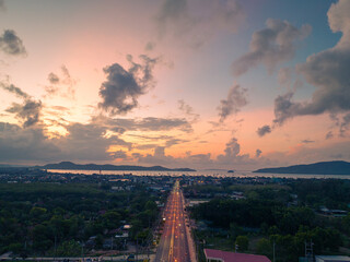 aerial view colorful sky at sunrise above the main road..aerial view scenery light through to sky above Chalong gulf..amazing sky of bright sunrise in nature and travel concept