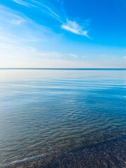 Obraz premium Blue sea horizon with some light clouds, seascape background