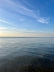 Blue sea horizon with some light clouds, seascape background
