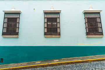 Minimalist duo tone blue teal wall with Wooden windows on street