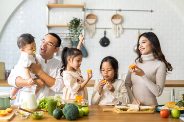 Portrait of enjoy happy love asian family father and mother with little asian girl daughter child having fun help cooking food healthy eat together with fresh vegetable salad and sandwich in kitchen