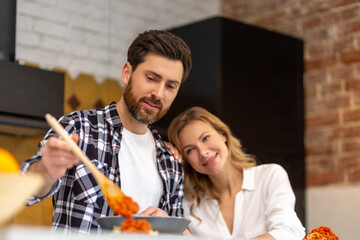 Happy family having dinner in kitchen serving table at home in domestic kitchenn.