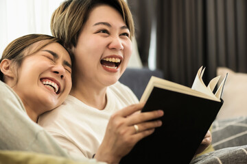 Happy young Asian lesbian couples smiling and reading book together, lesbian lovers and LGBT Concept