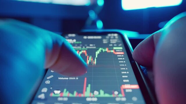 First person trader investor with a phone analyzes the cryptocurrency market