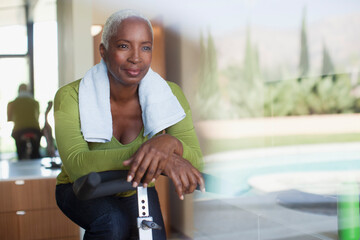 Older woman sitting on exercise bike in home