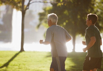 Older men jogging together in park - obrazy, fototapety, plakaty