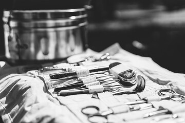 Old Medical And Surgical Instruments. Many Surgical Instruments For Surgery. Old Different Metal Medical Instruments Objects. Retro Stainless Surgical Equipment Tools. Black And White Toned Shot