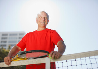 Older man playing tennis on court