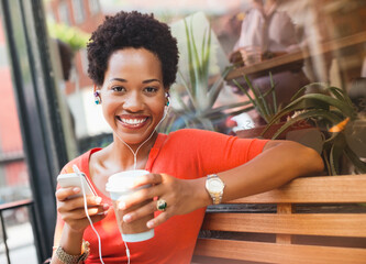 Woman listening to earphones by coffee shop