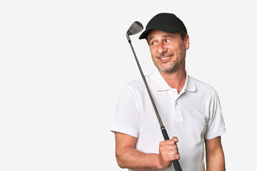 Middle aged golfer man looks aside smiling, cheerful and pleasant.